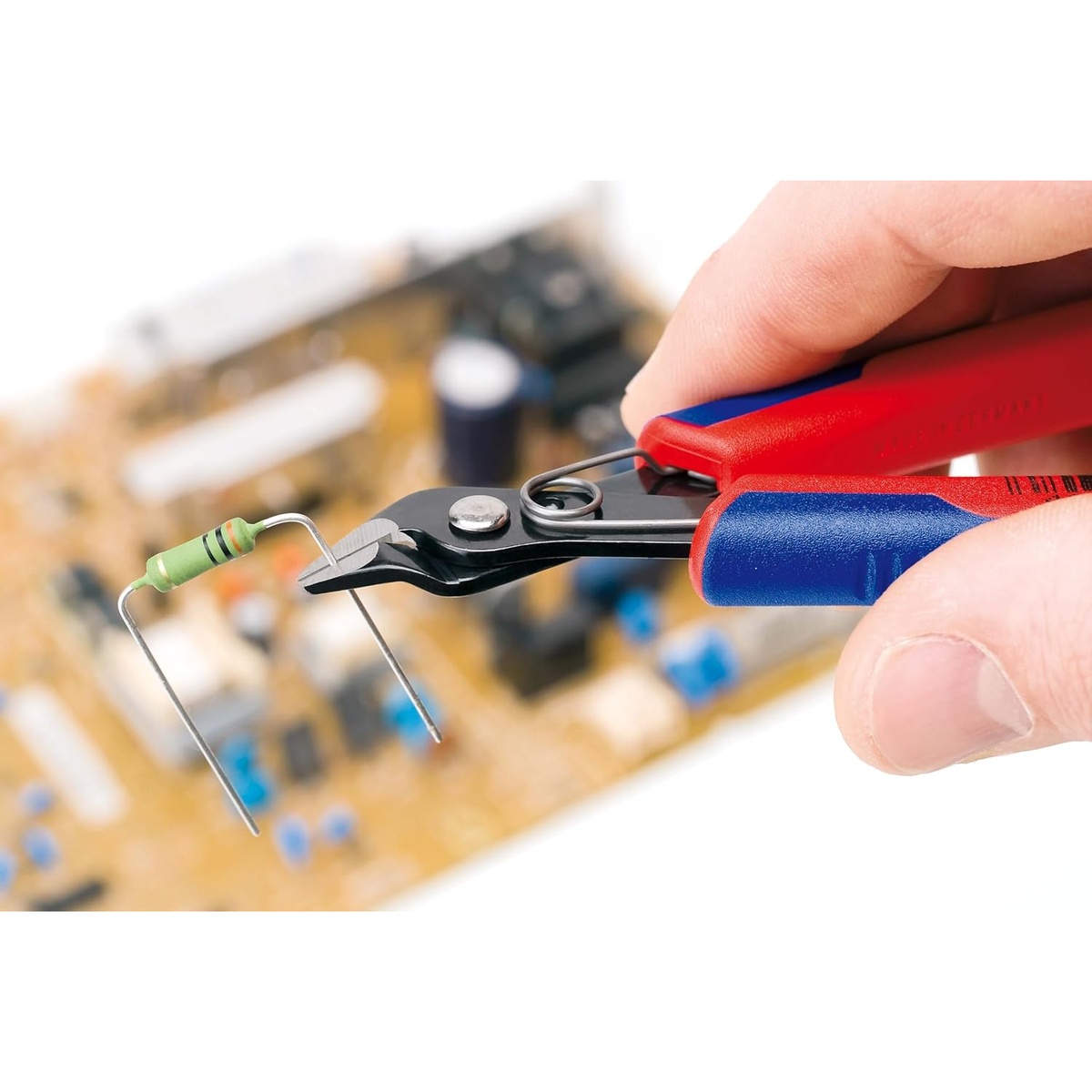 Knipex 78 61 125 SBA Electronics Super Knips trimming a resistor lead during electronics assembly over a circuit board work area