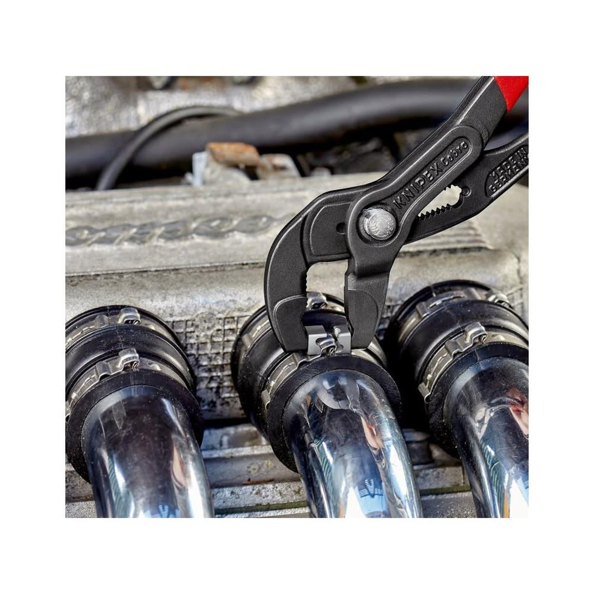 Knipex Hose Clamp Pliers with Plastic Handle 180 mm opening a hose clamp on engine bay tubing during automotive service work
