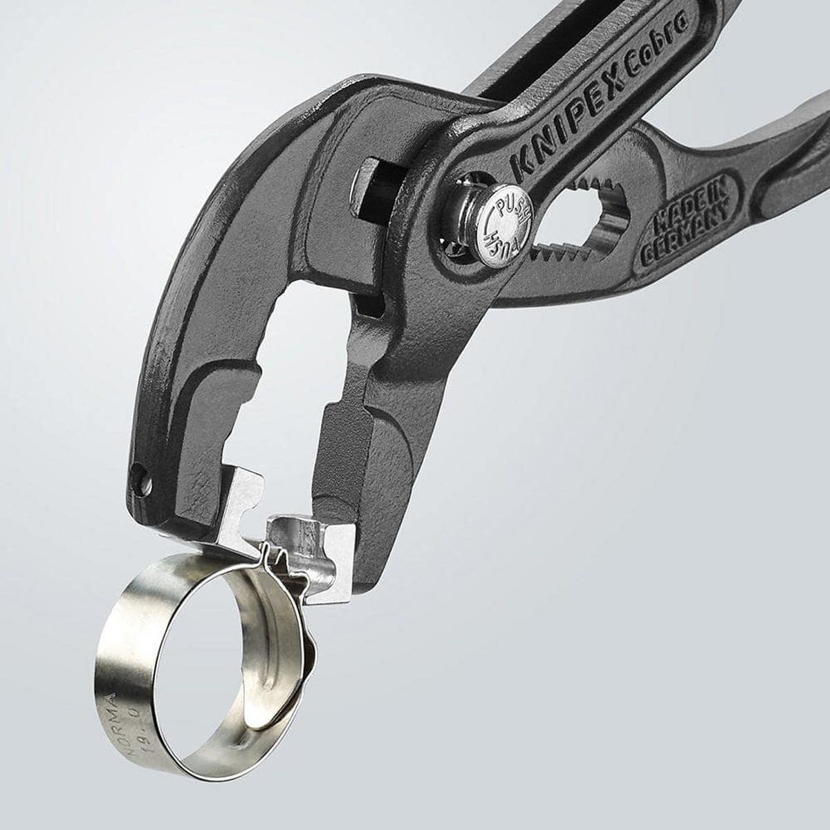 Close-up of Knipex 85 51 250 C SBA hose clamp pliers engaging a click clamp at the jaw tips