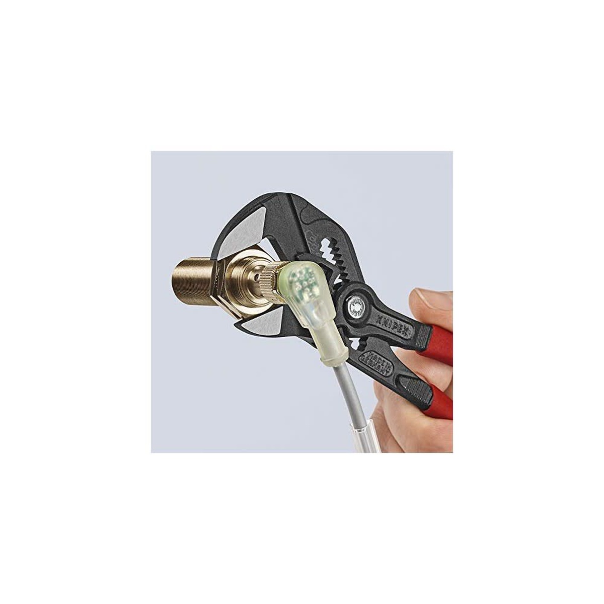 Knipex Black Atramentized Pliers Wrench 180mm gripping a brass fitting during installation work without damaging the finished surface