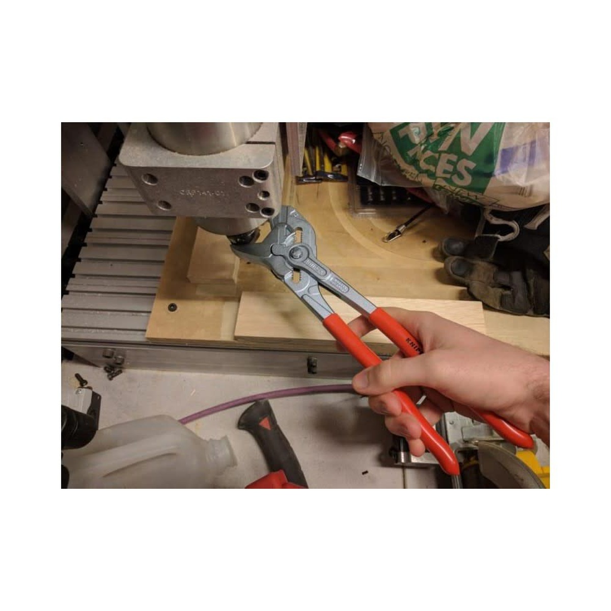Knipex 86 03 300 SBA Pliers Wrench being used on machine hardware in a workshop setting