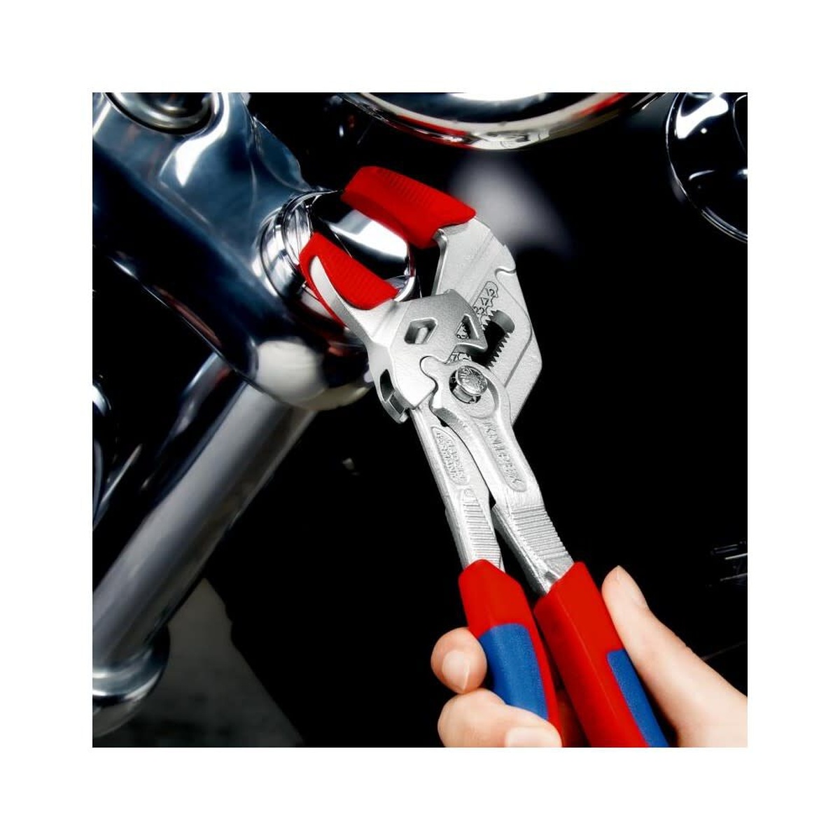 Knipex pliers wrench being adjusted on a polished fitting in a tight mechanical workspace during service work