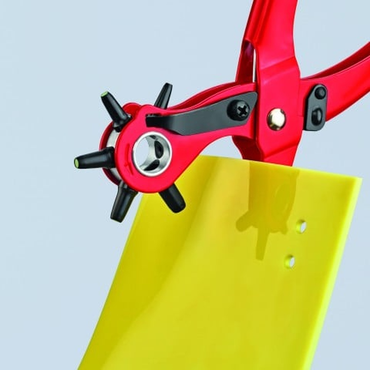 Knipex 90 70 220 Revolving Punch Pliers punching holes in yellow plastic sheet material for layout and fastening work