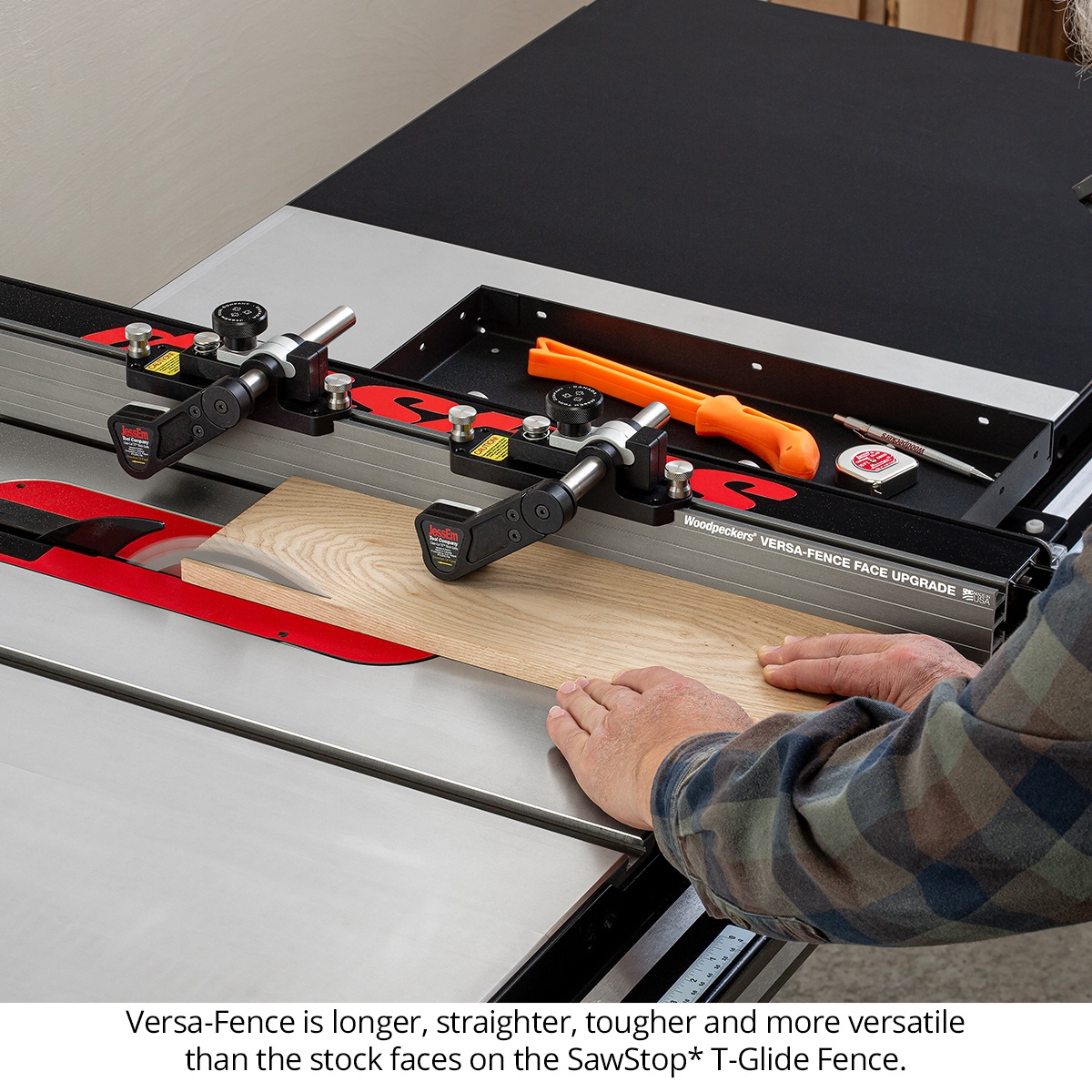 Woodpeckers Versa-Fence Face Upgrade for SawStop table saw guiding hardwood across the fence during a rip cut in a woodworking shop