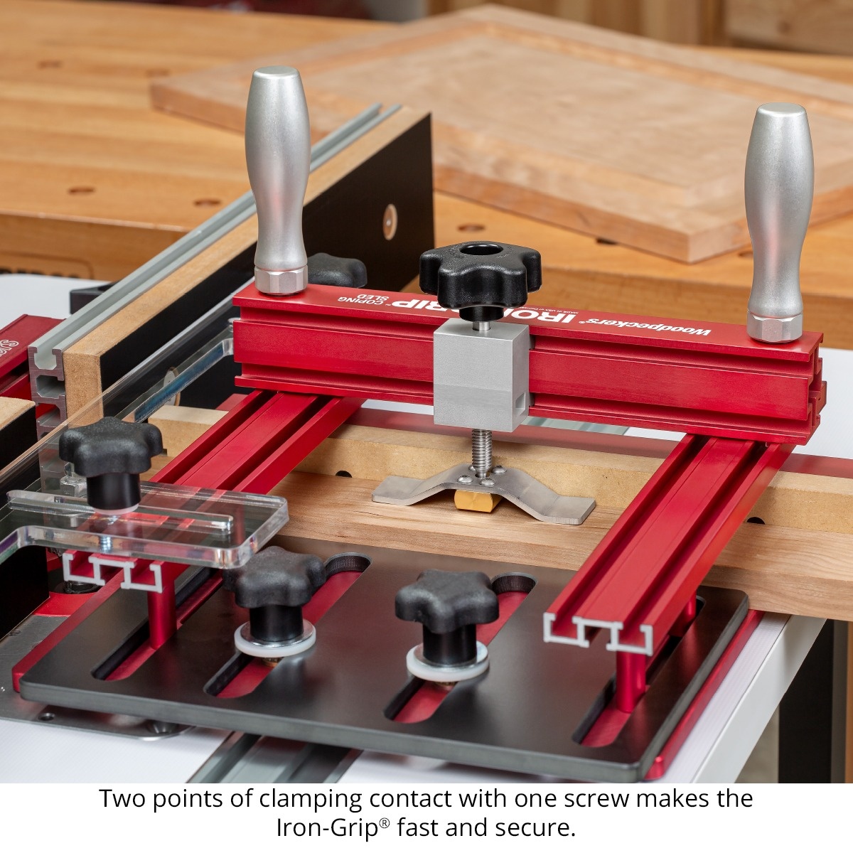 Woodpeckers Iron-Grip Clamp Upgrade on a coping sled holding a wood workpiece with two-point clamping during router table joinery