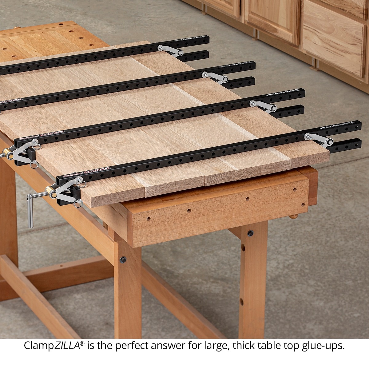 Woodpeckers ClampZILLA 3.0 4-Way Panel Clamp securing a large hardwood table top glue-up on a woodworking bench
