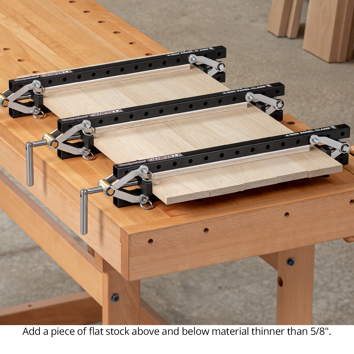 Woodpeckers ClampZILLA 3.0 4-Way Panel Clamp securing multiple wood boards for a flat panel glue-up on a woodworking bench