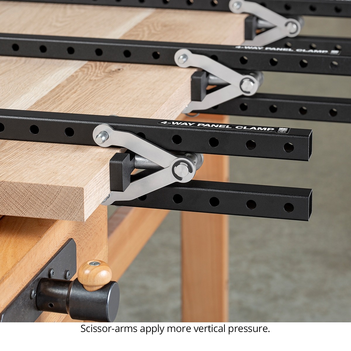 Woodpeckers ClampZILLA 3.0 4-Way Panel Clamp applying even pressure across a large wood table top glue-up on a workbench