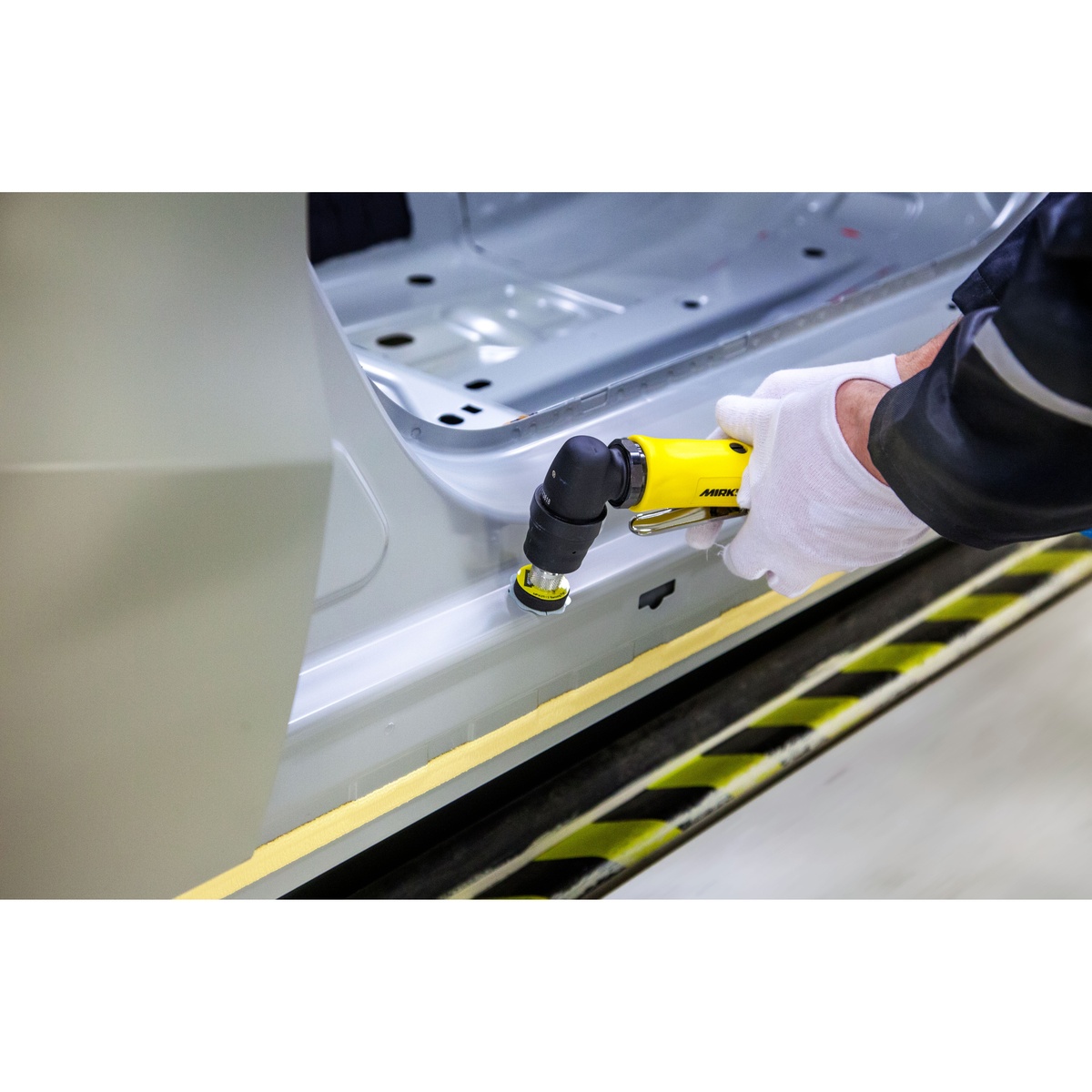 Mirka MAOS130 1.25 inch angled orbital sander performing spot repair on an automotive body panel during paint defect correction