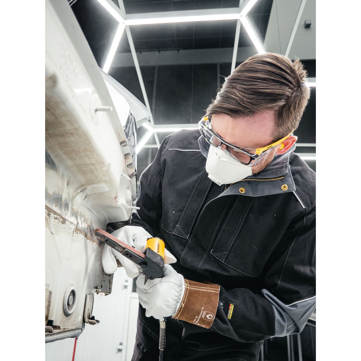Mirka PBS-13457 Pneumatic Belt Sander removing material on an automotive body panel during collision repair work in a shop