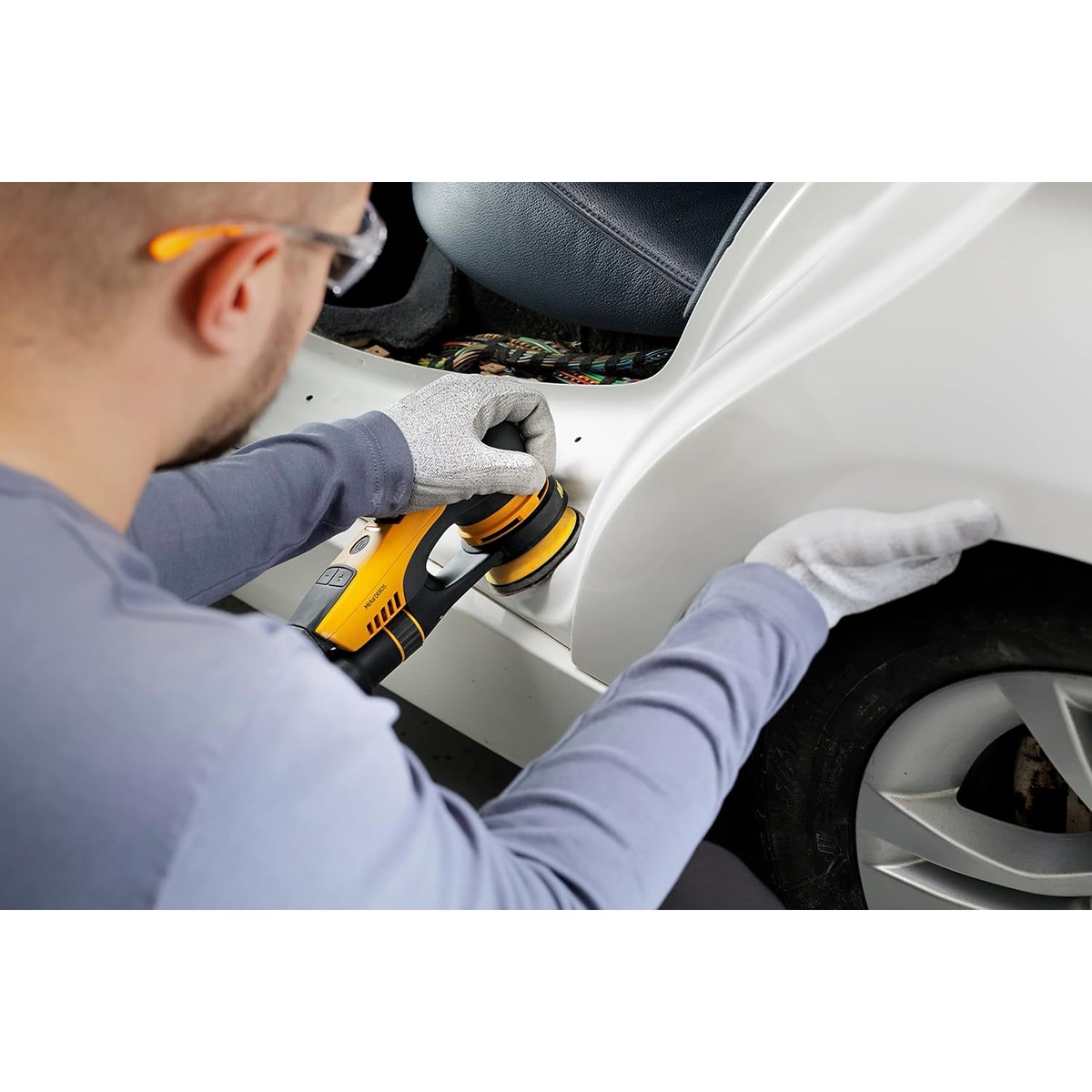 Mirka DEROS 350X CV Electric Random Orbital Sander sanding an automotive body panel in a tight wheel arch repair area during detail refinishing work