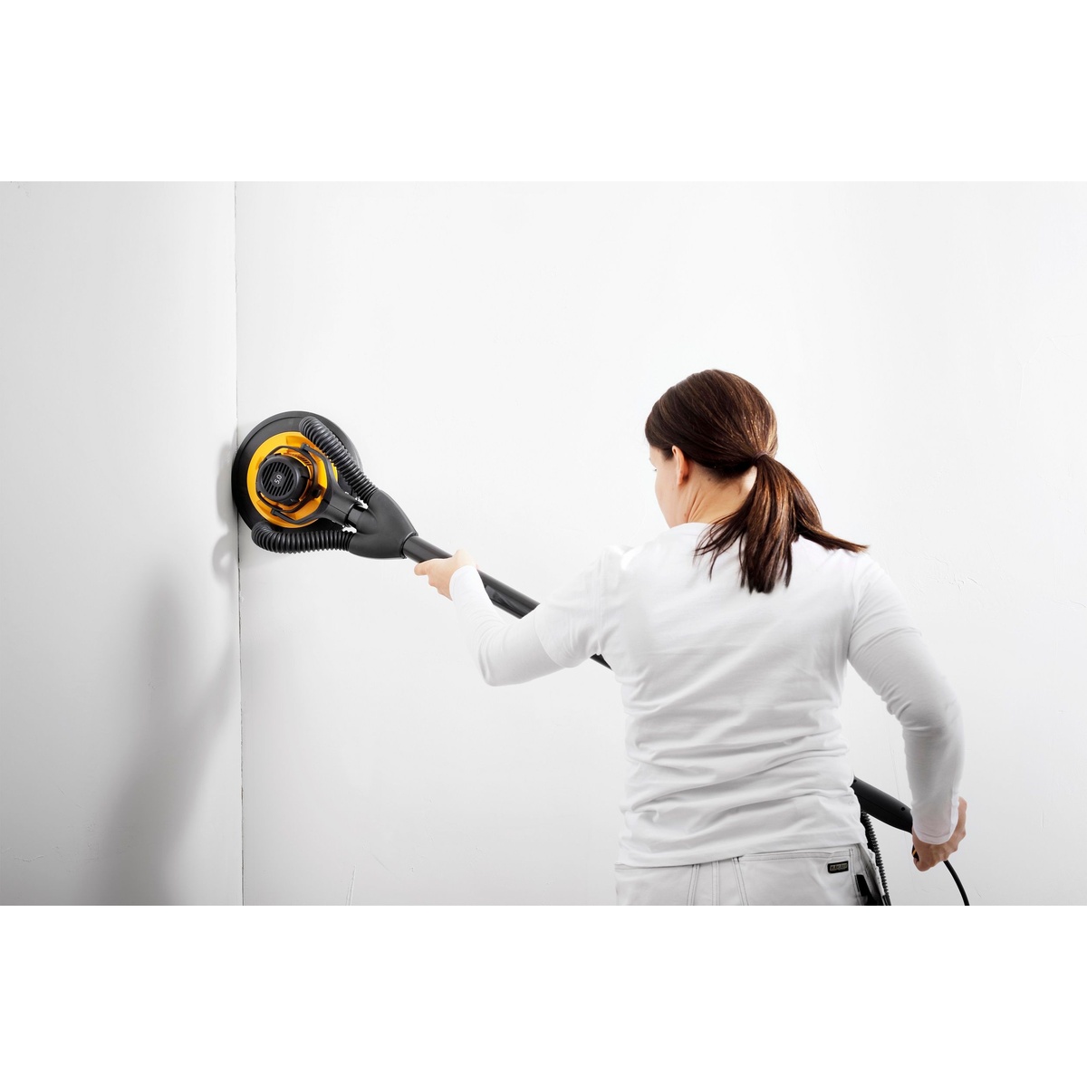 Mirka LEROS 950XCV 9 in 5 mm Wall Sander with Bag sanding an interior wall during drywall finishing work
