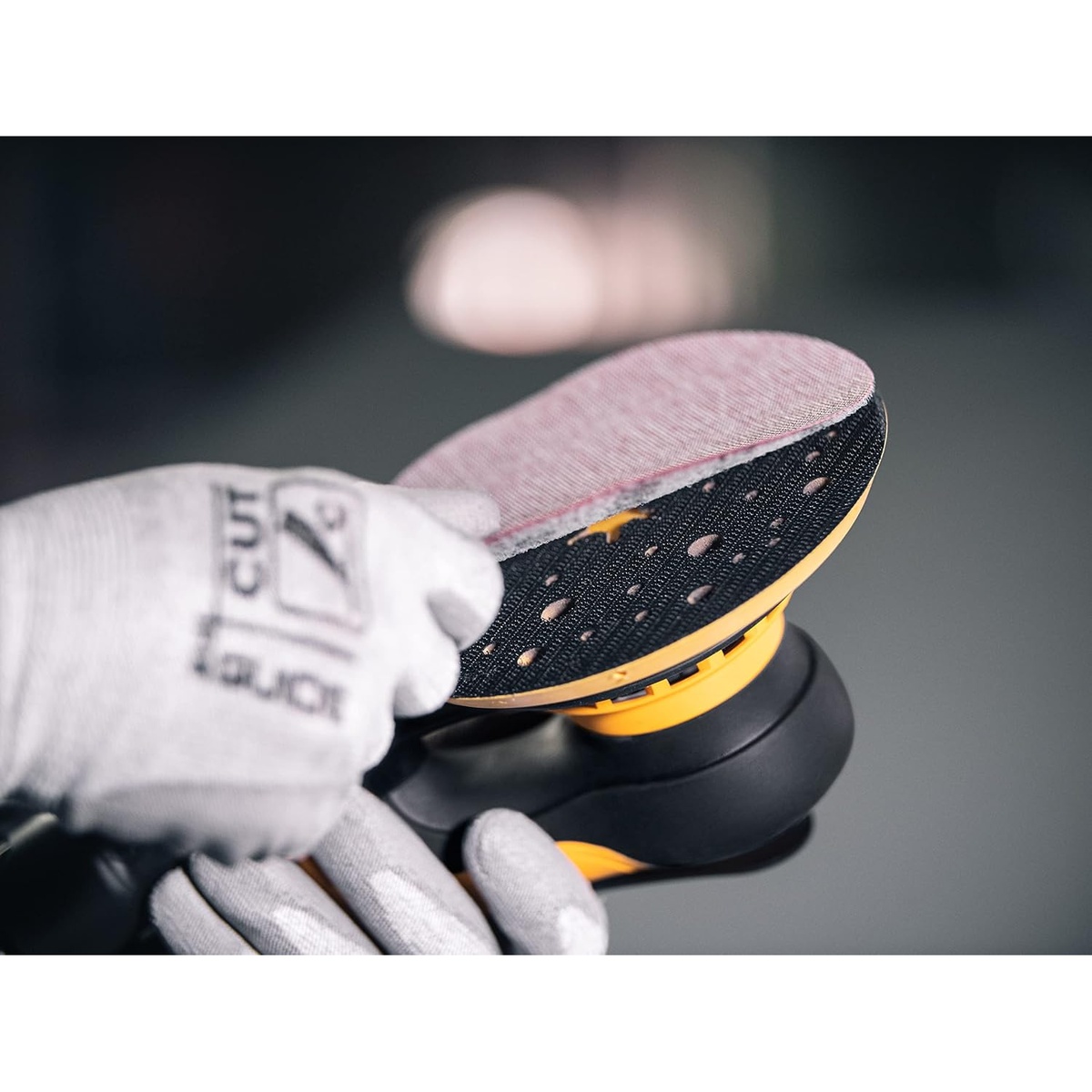 Mirka DEROS 625X CV Electric Random Orbital Sander with a 6 inch sanding disc being installed for finish sanding in a professional shop setting