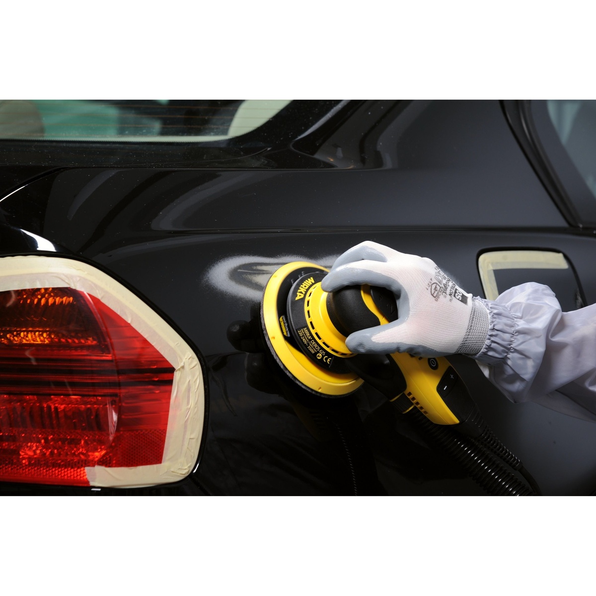 Mirka DEROS II 625X Electric Powered 6 Inch 2-1/2 mm Orbital Sander with Case sanding an automotive body panel during surface prep work in a refinishing shop