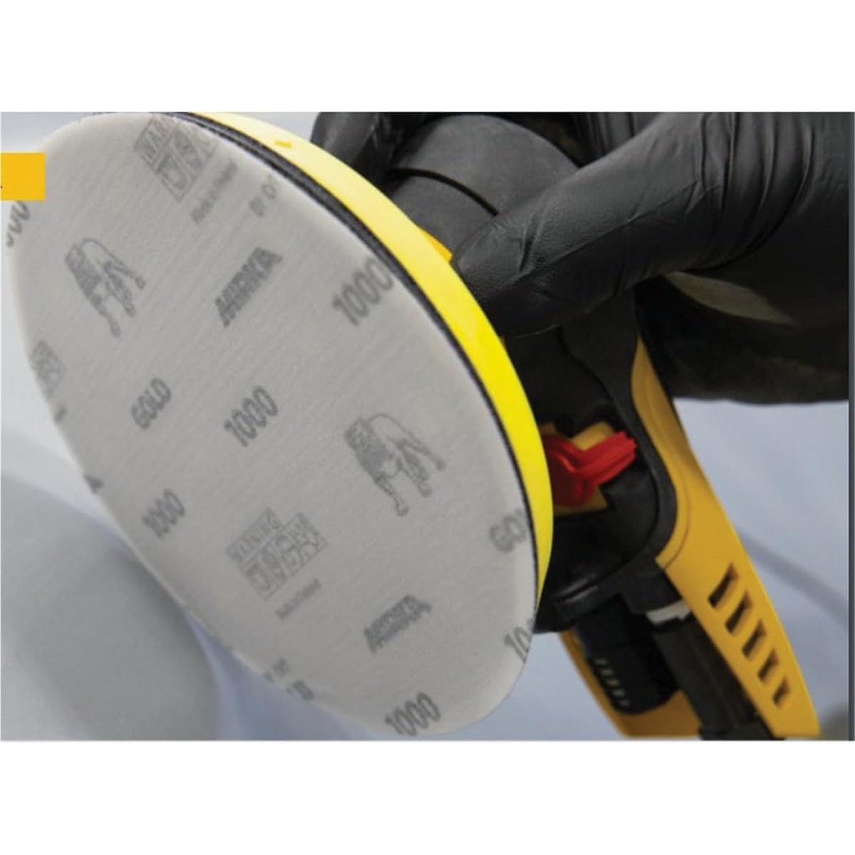 Mirka Abrasives Gold 23-6NHF-1500 Semi Open-Coated Sanding Disc mounted on a 6 inch power sander for fine surface sanding and finish prep work