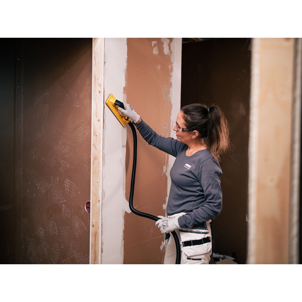 Mirka ABRANET 4.5 x 32.8 foot grip sanding roll used for wall and filler sanding with vacuum-assisted hand sanding on an interior remodeling job