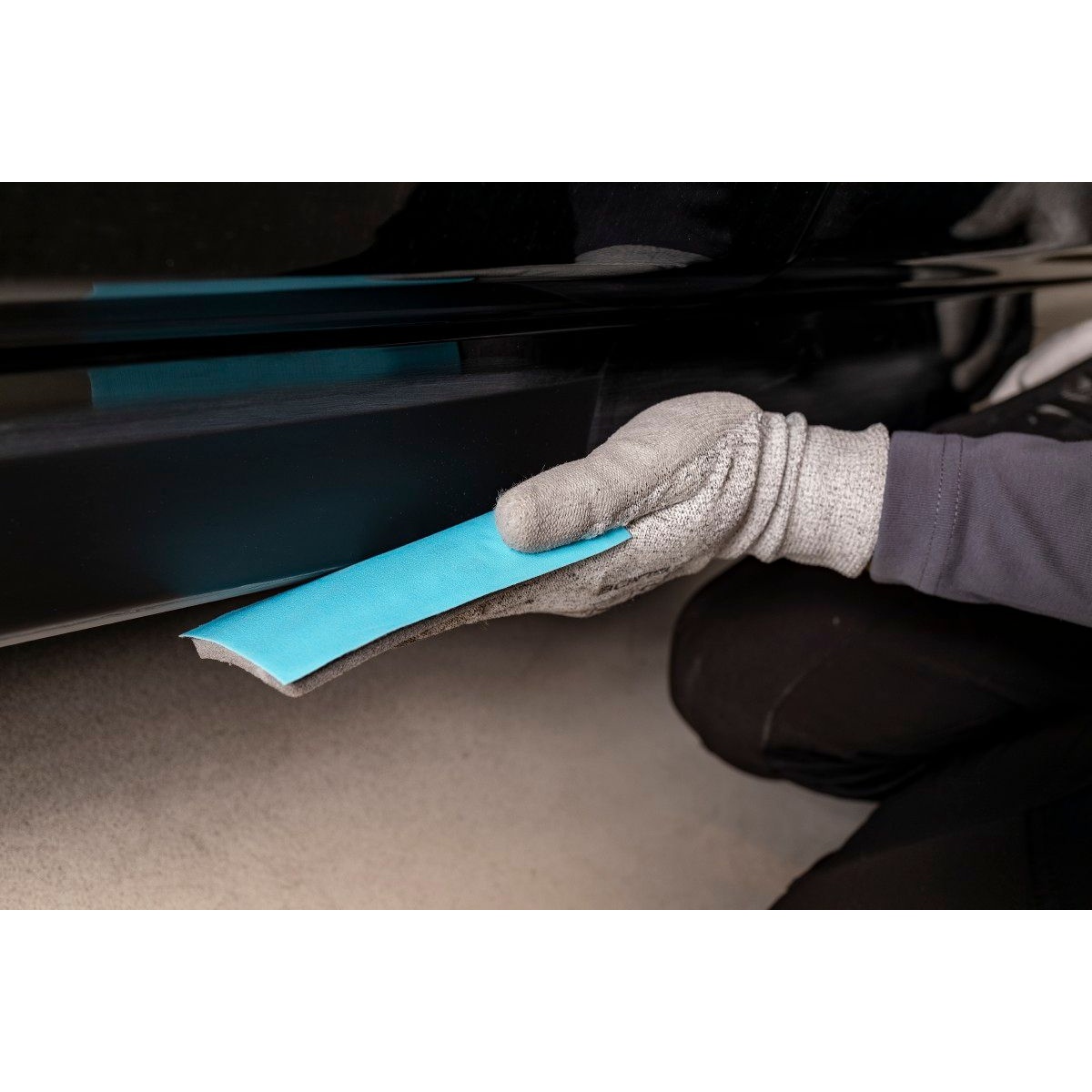Mirka NOVASTAR FLEX hand sanding sheet folded for dry sanding along a narrow lower vehicle panel edge
