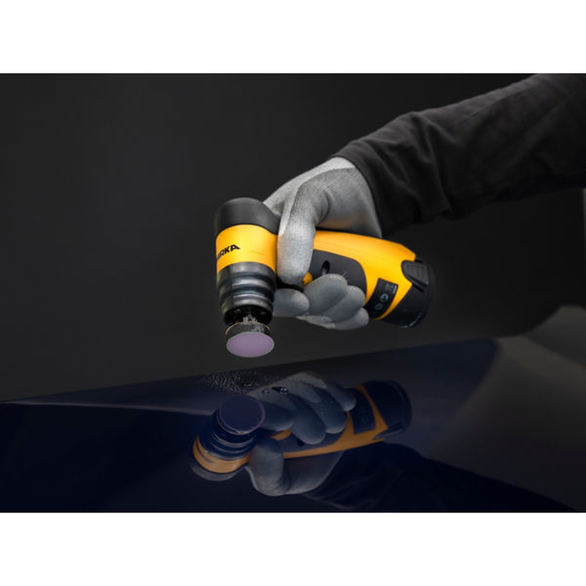 Mirka Iridium SR 1.25 inch diameter PSA abrasive disc refining an automotive clearcoat surface with a Mirka spot repair sander in a finishing workflow