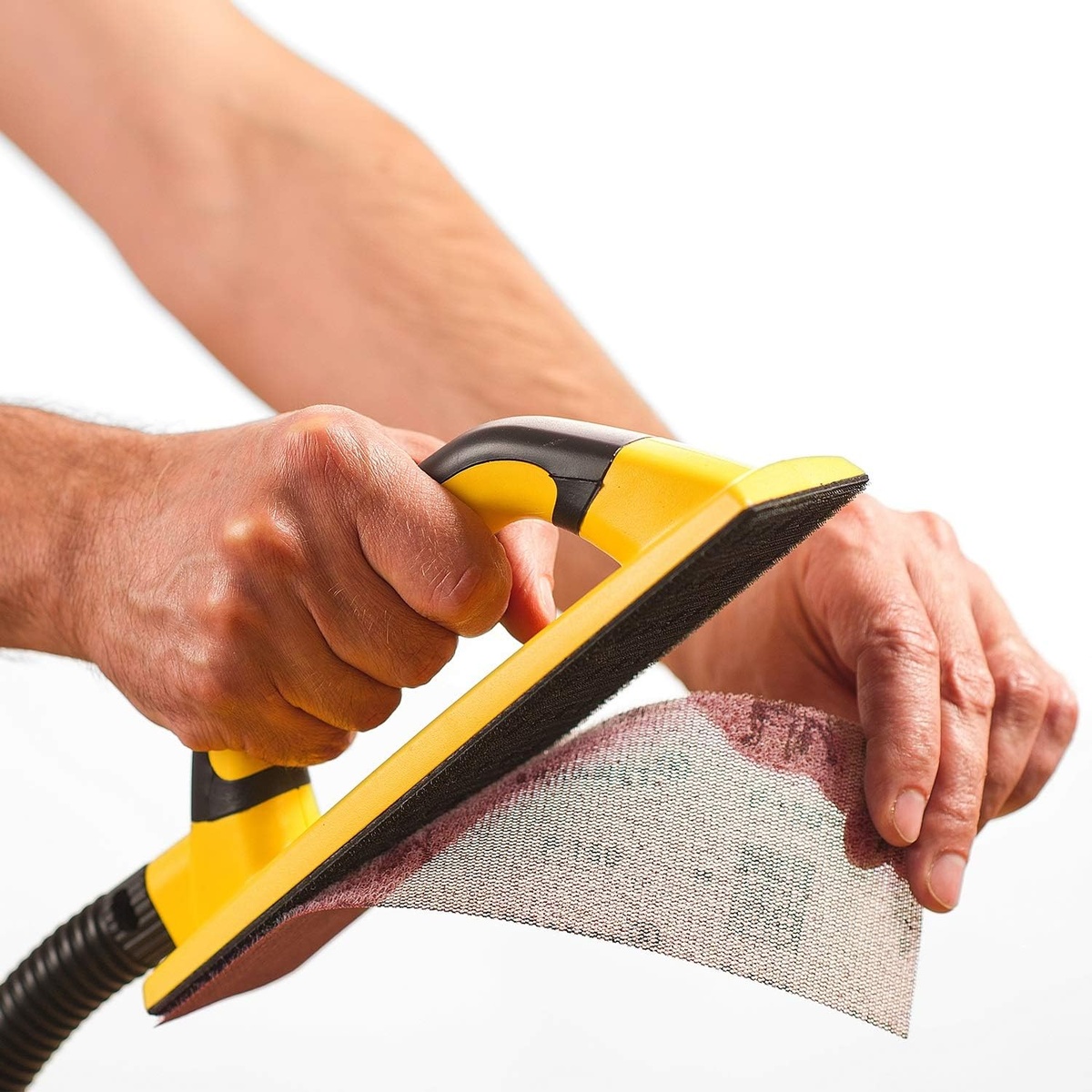 Mirka 9A-175-120 Abranet Net Sandpaper Strips mounted on a hand sanding block during dust-controlled sanding work on a surface in a workshop setting