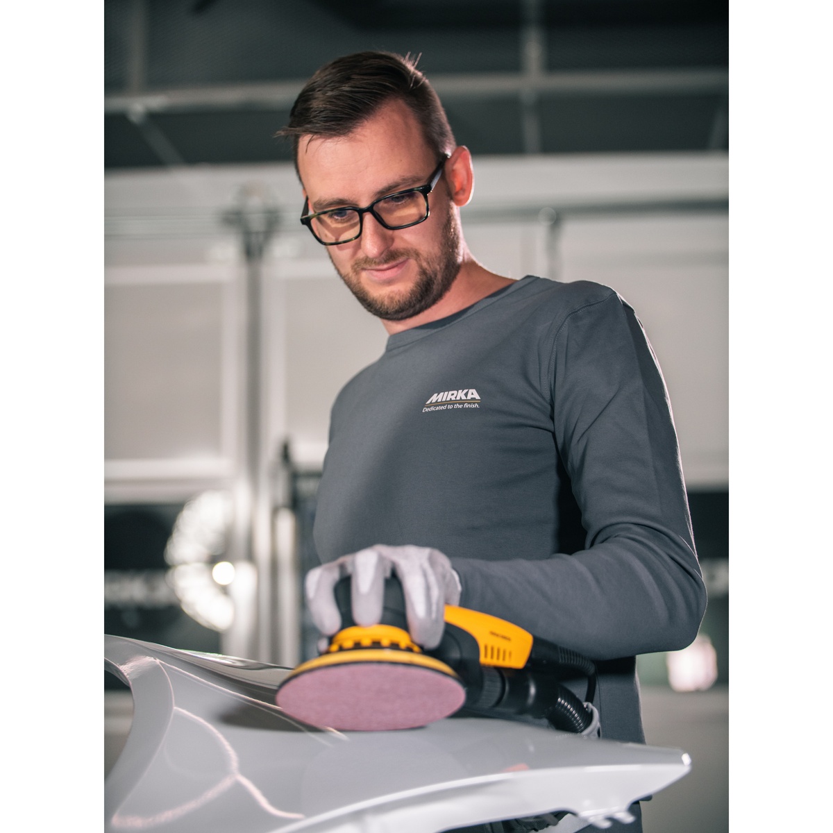 Mirka Abranet Ace HD 8 inch Grip sanding disc mounted on a random orbit sander during automotive surface sanding with dust extraction