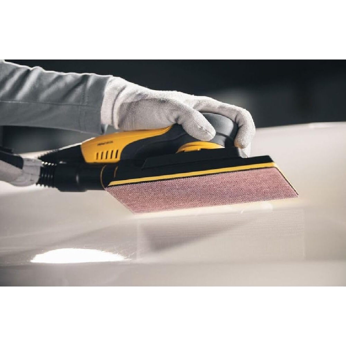 Mirka ABRANET 30 Ft. x 2-3/4 Inch P120 Grit Sanding Roll used on a vacuum-assisted sheet sander for smooth surface sanding in a finishing workspace
