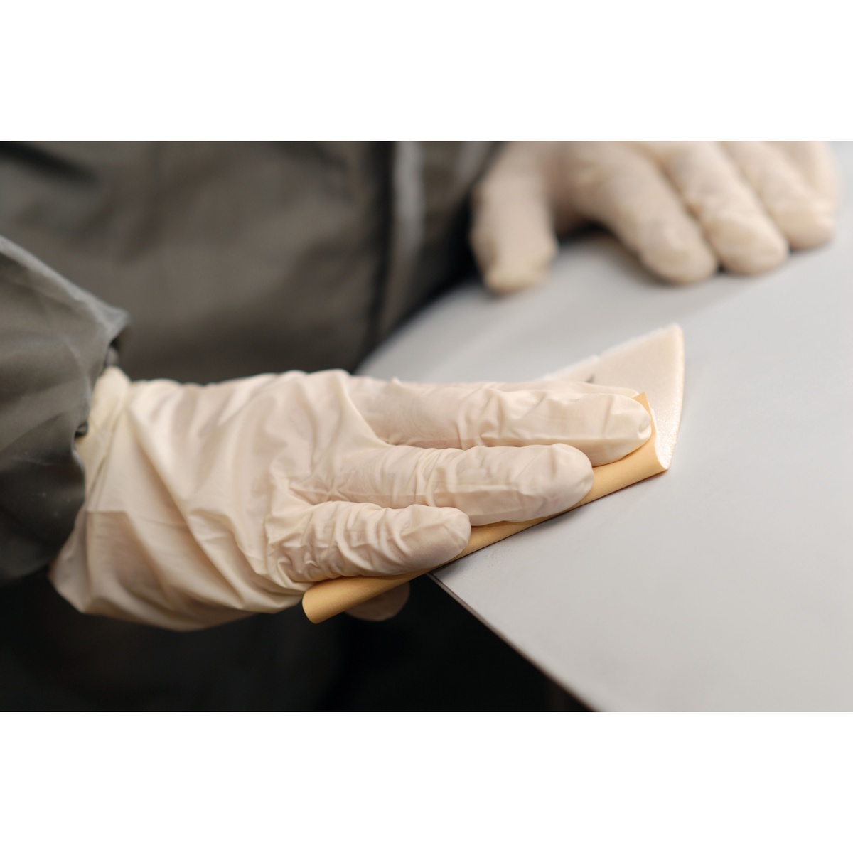 Mirka Goldflex Soft 4.5 in x 5 in Plain Roll P150 hand sanding sheet flexing over a curved coated panel during detail sanding work