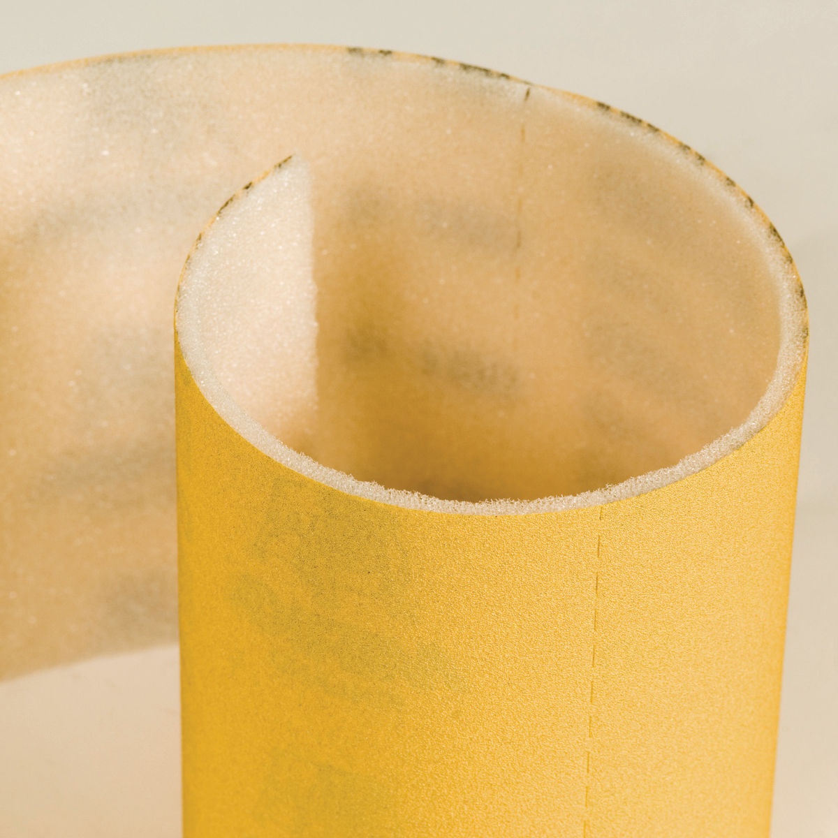 Mirka Goldflex Soft 4.5 in x 5 in Plain Roll P150 close-up showing foam-backed abrasive construction for controlled sanding on detailed surfaces