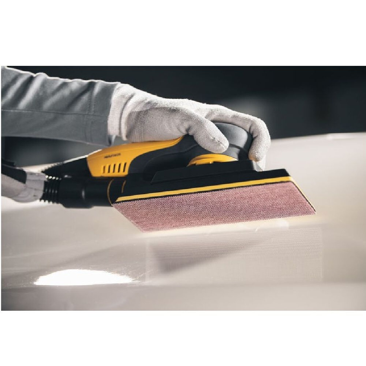 Mirka ABRANET 30 Ft. x 2-3/4 Inch P80 Grit Sanding Roll used on a vacuum-assisted sanding block smoothing a solid surface panel in a workshop