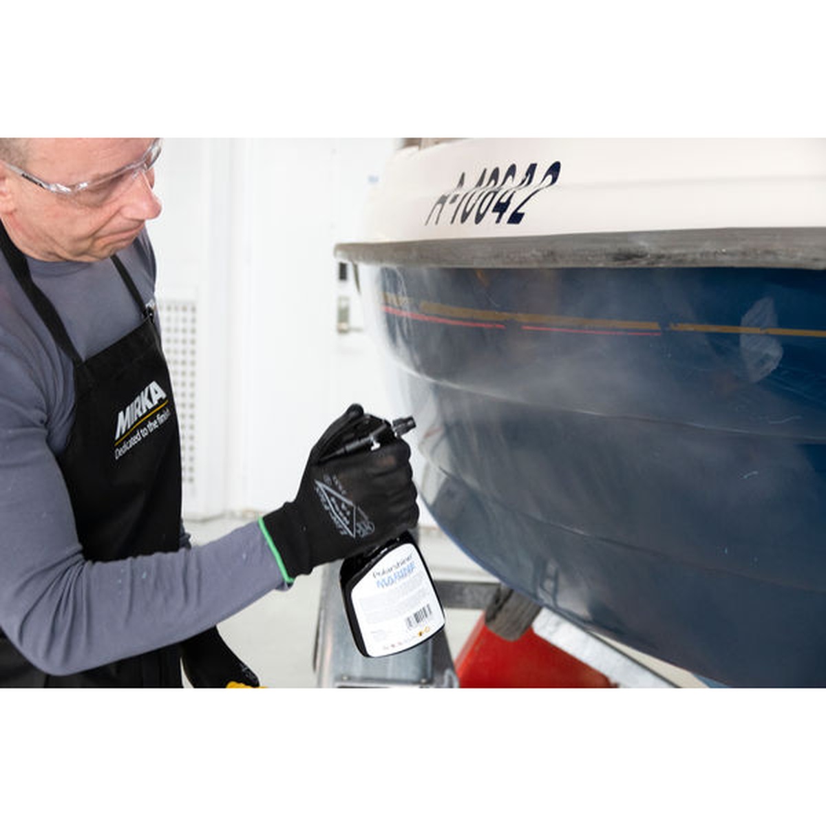 Mirka Polarshine Marine Final Finish being sprayed onto a boat hull during marine detailing to remove residue and leave a clean final surface