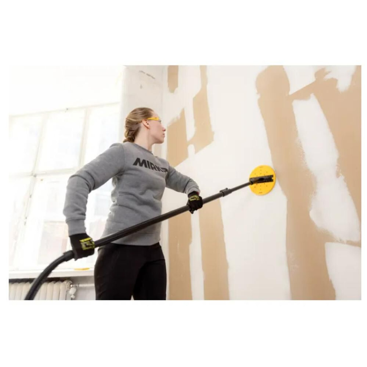 Mirka ABRANET YELLOW 9 Inch Medium Abrasive 20 Pieces used on a long-neck sander for drywall wall sanding in an interior finishing job
