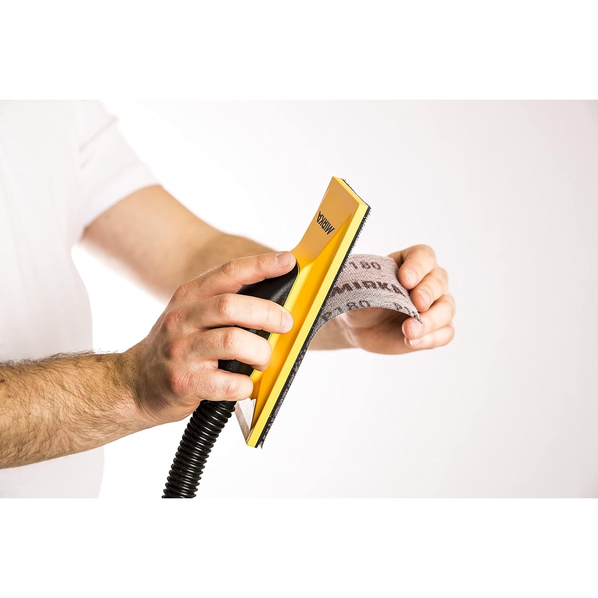 Mirka 9A-150-APRP Abranet Net Sanding Sheets attached to a hand sanding block for vacuum-assisted sanding during surface preparation