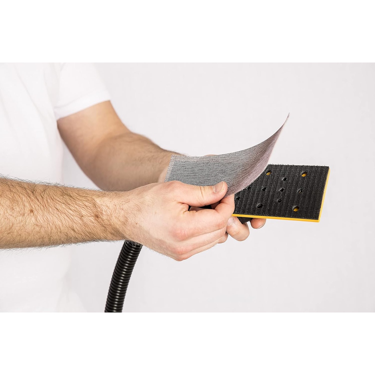 Mirka 9A-150-APRP Abranet Net Sanding Sheets being fitted onto a hook and loop sanding pad for straight line sanding and hand sanding