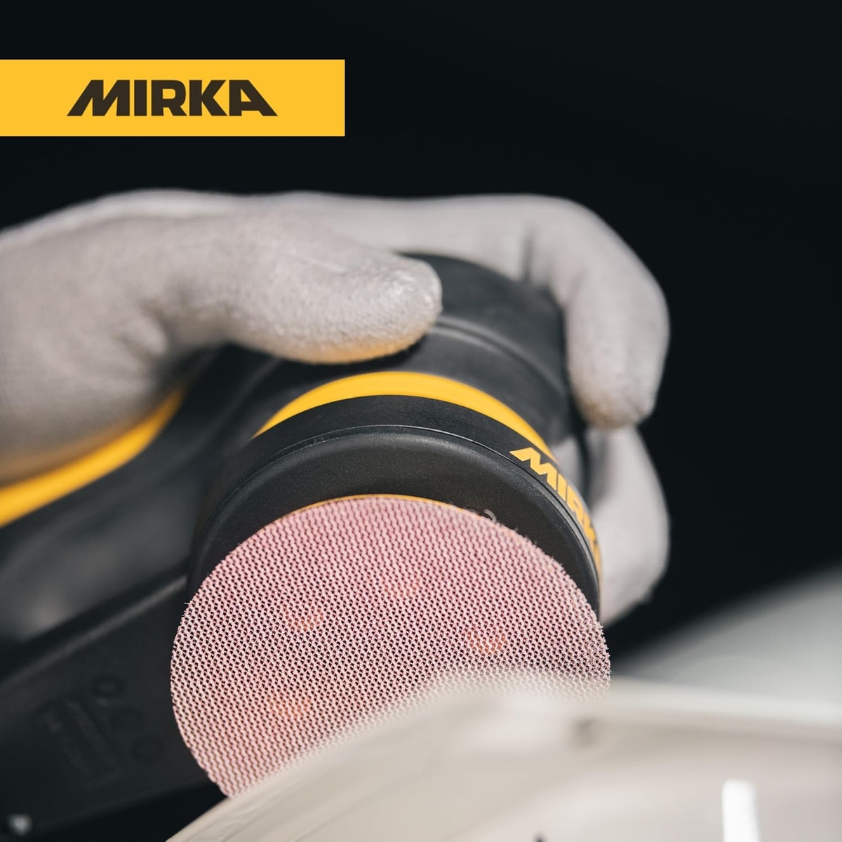 Mirka Abranet 9A-203-120 3 inch sanding disc mounted on an orbital sander for dust-controlled surface prep in a workshop