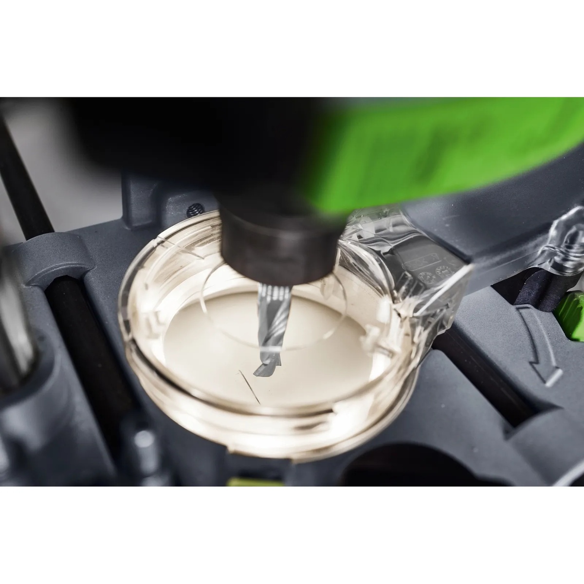 Festool LM-OF 1400 extraction bonnet with light module installed around a router bit during close-up routing work for better cutter visibility