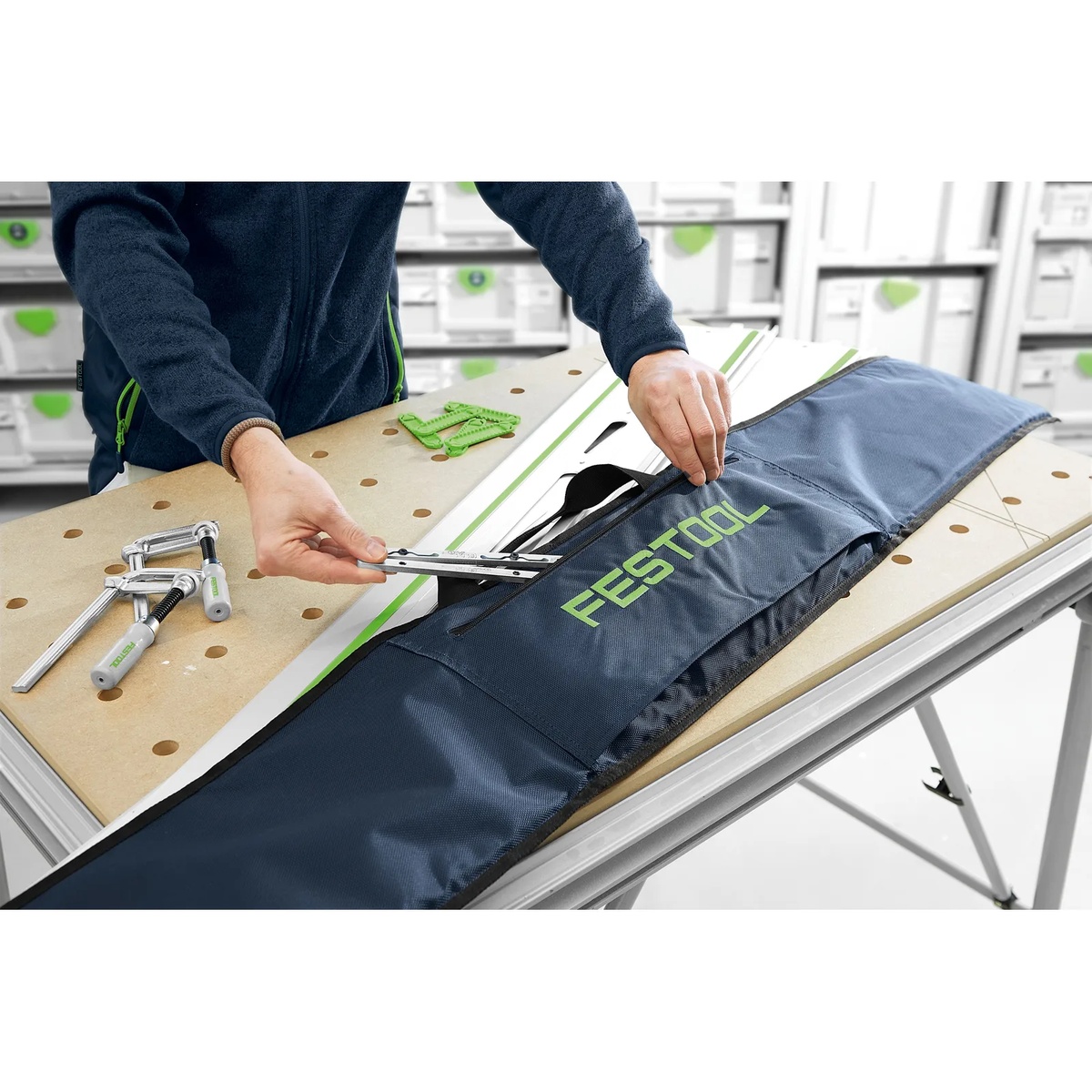 Festool 466357 Guide Rail Tote Bag for 55 inch rails on a worktable with a guide rail and rail accessories during workshop setup