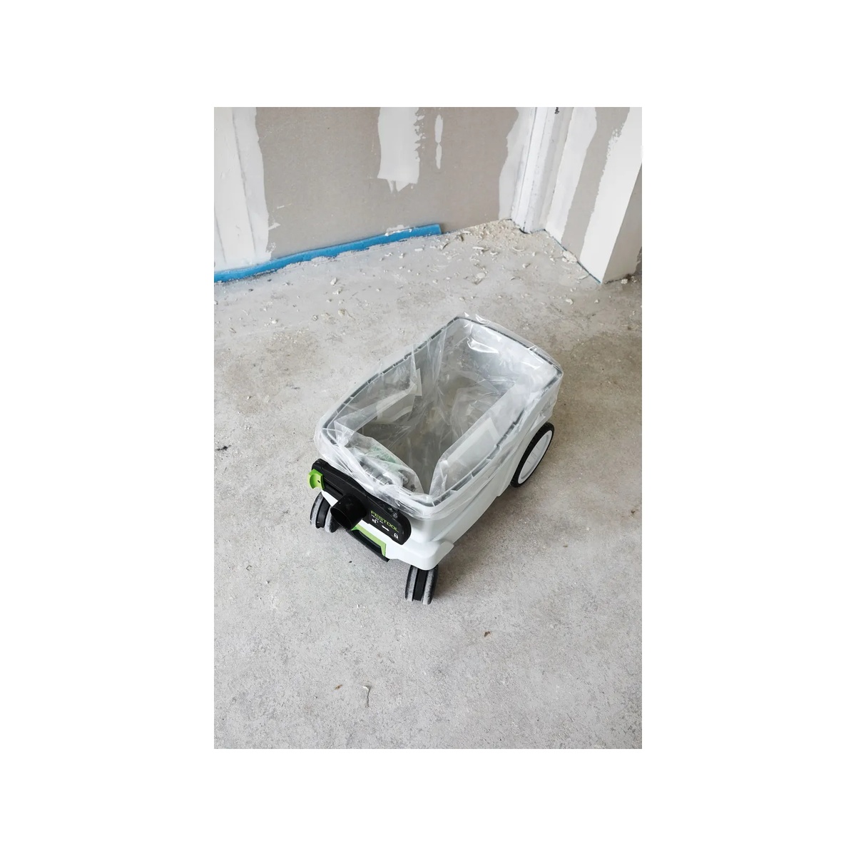 Festool 496215 Disposable Dust Liners 5 Pack installed in a CT 36 AC dust extractor on a drywall jobsite floor during sanding cleanup