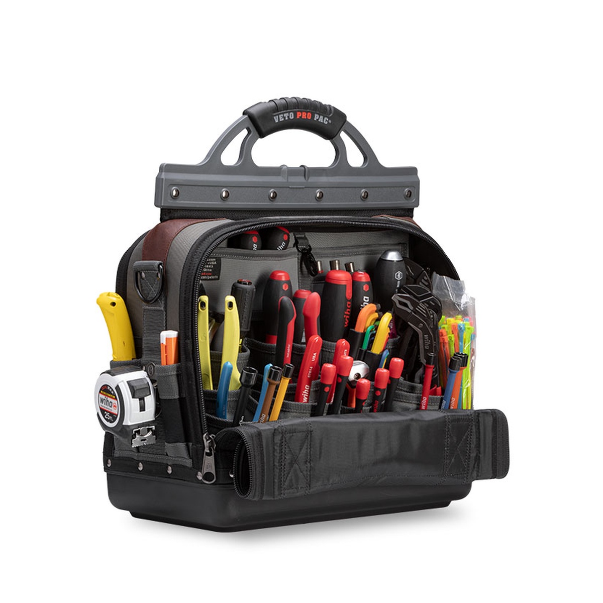 Veto Pro Pac Tech-XL Extra Large Tech Tool Bag opened on a work-ready setup with hand tools, measuring tape, and organized pockets for service technician tasks