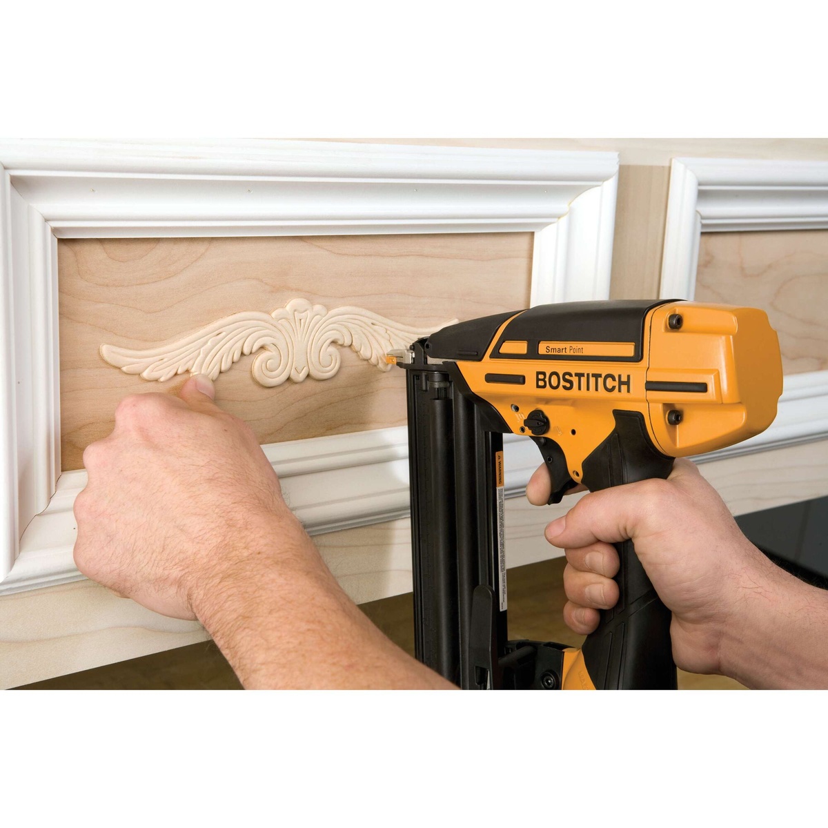 Bostitch BTFP12233 Smart Point 18 Gauge Brad Nailer Kit fastening decorative molding on a finished interior wood panel for trim and cabinet detail work