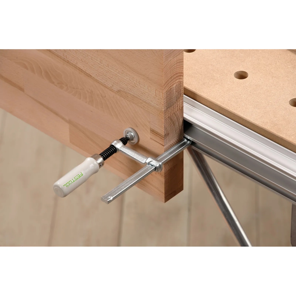 Festool 489570 Screw Clamps securing a wood workpiece to a Festool MFT table during bench setup for precise woodworking