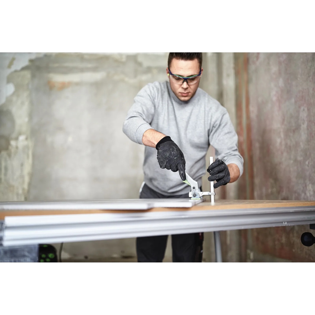 Festool FS-HZ 160 Quick Clamp securing material to a Festool guide rail on a work table during precision panel cutting in a workshop