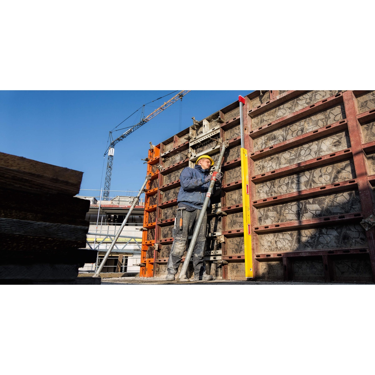 Stabila 34610 6-to-10-foot Expandable Magnetic Plate Spirit Level attached vertically to formwork on a construction site for plumb checking