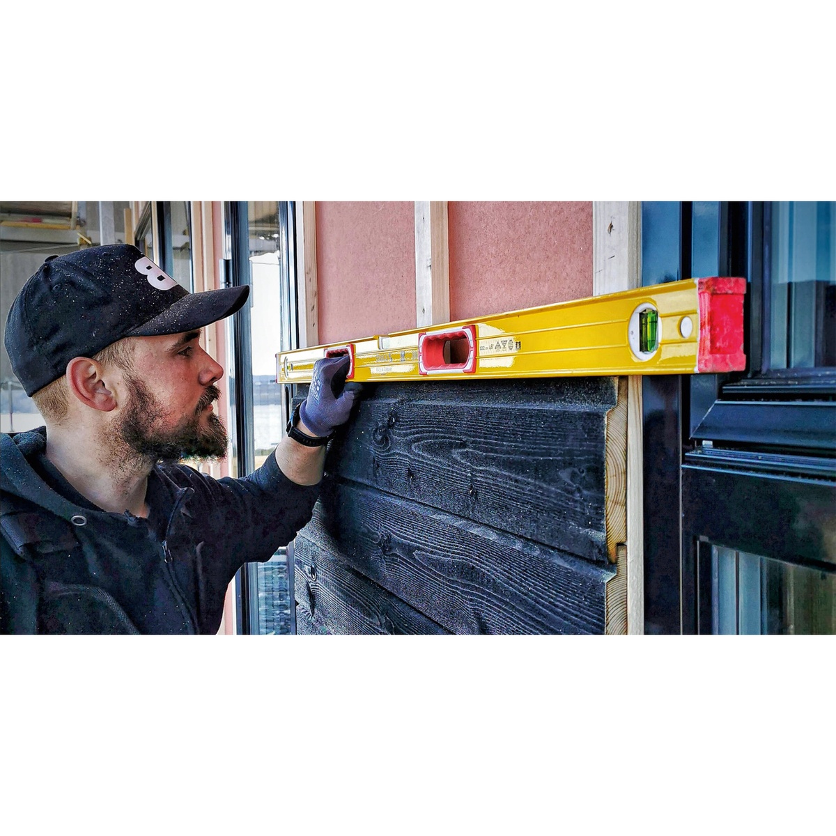 Stabila 37816 48-inch & 16-inch Type 196 2-Piece Spirit Level Set checking a horizontal installation on exterior cladding at a building site