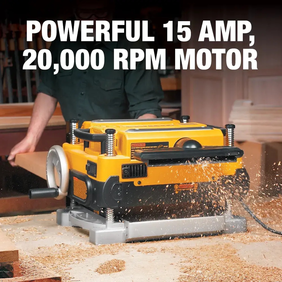 DeWALT DW735X 13-In. 3-Knife Two Speed Thickness Planer in use planing a wood board in a workshop with chips ejecting from the cutter area