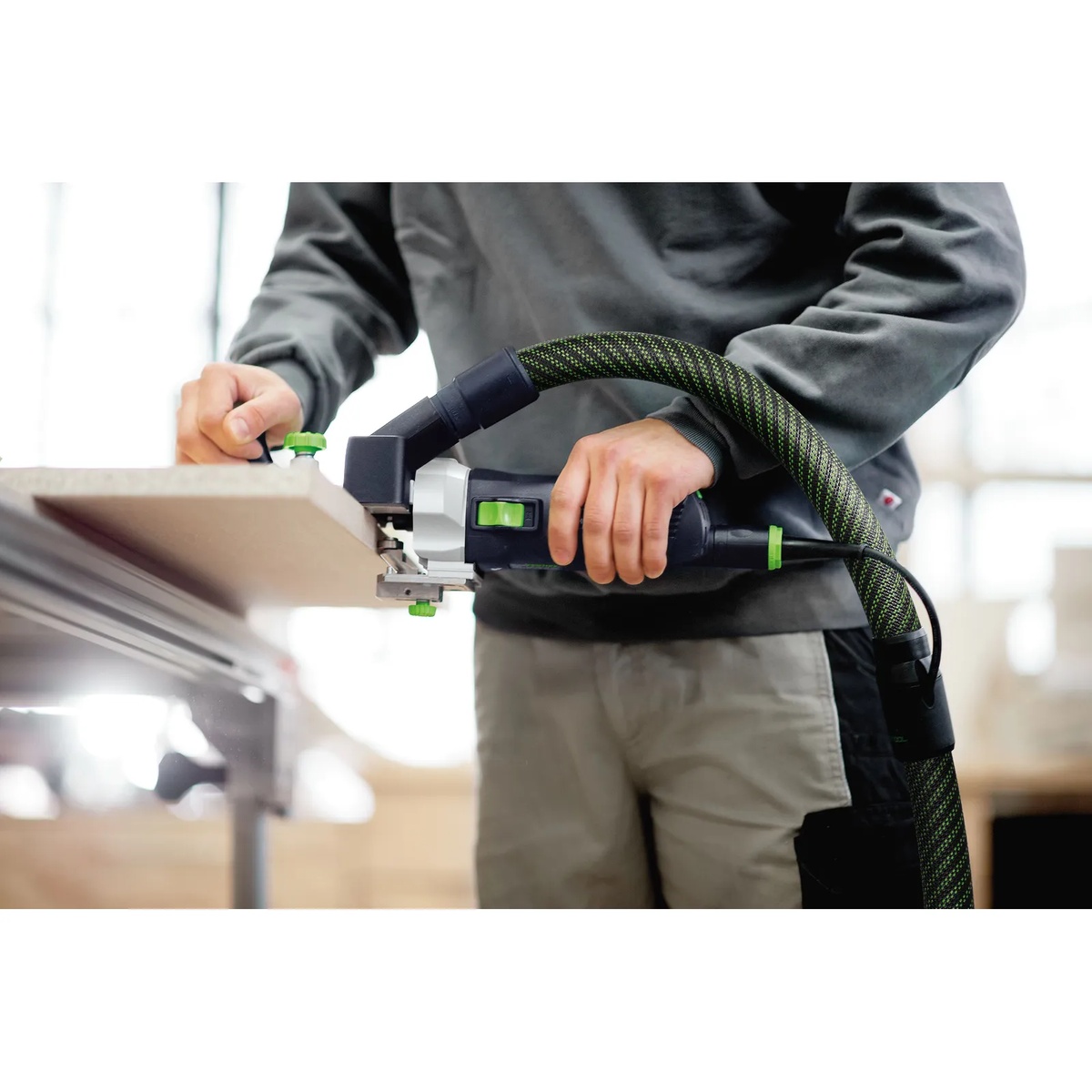 Festool 495165 1.5 Degree Horizontal Base MFK700 trimming edge banding on a panel in a workshop with dust extraction attached