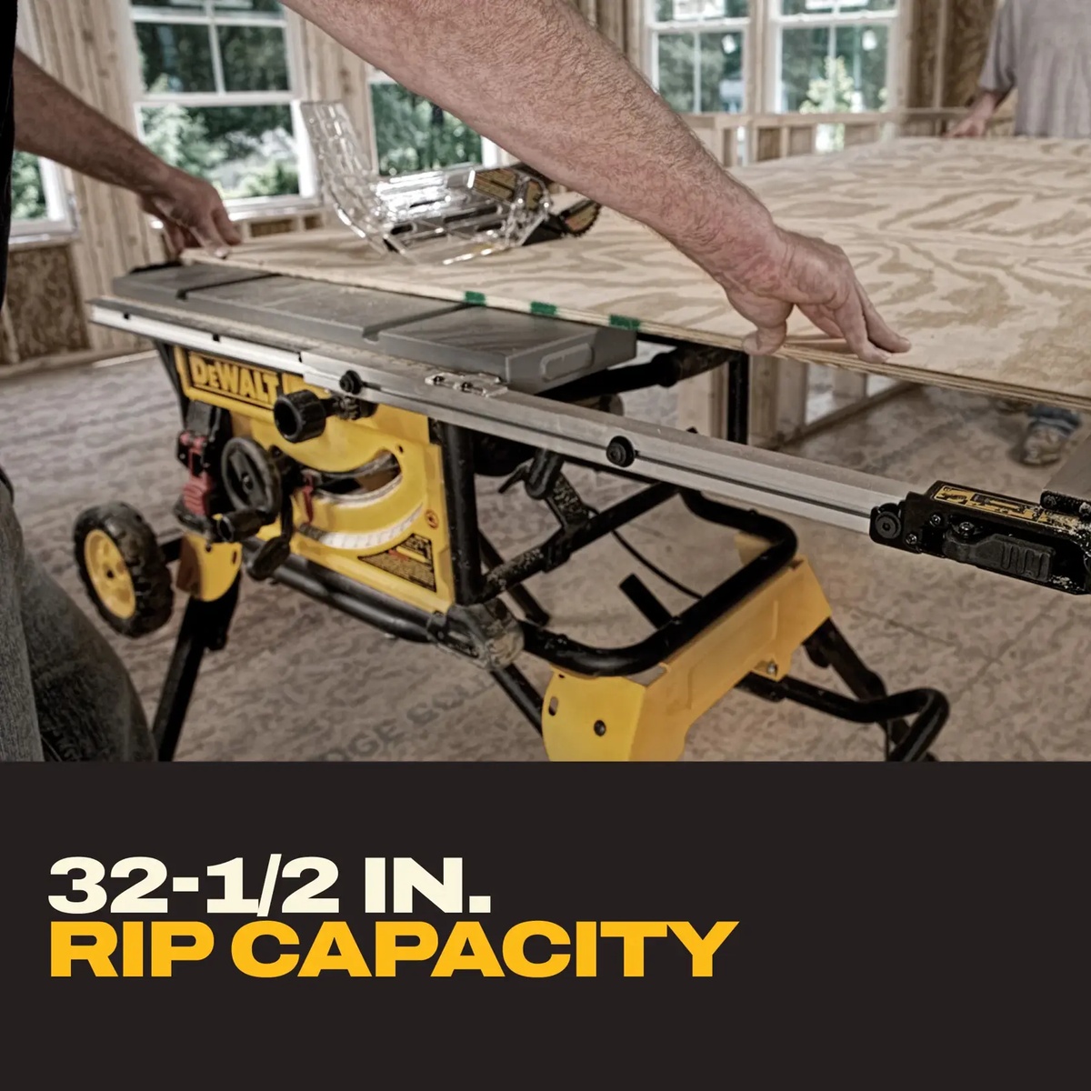 DEWALT DWE7491RS 10-In. Jobsite Table Saw and Rolling Stand ripping a wide sheet of plywood inside a framed jobsite, showing large panel support and wide rip capacity
