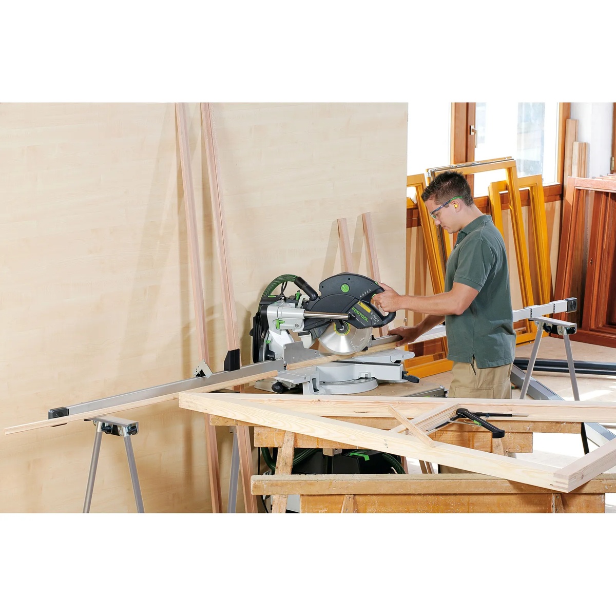 Festool Kapex setup on the MFT KAPEX table cutting long wood stock in a workshop with trim and framing material nearby