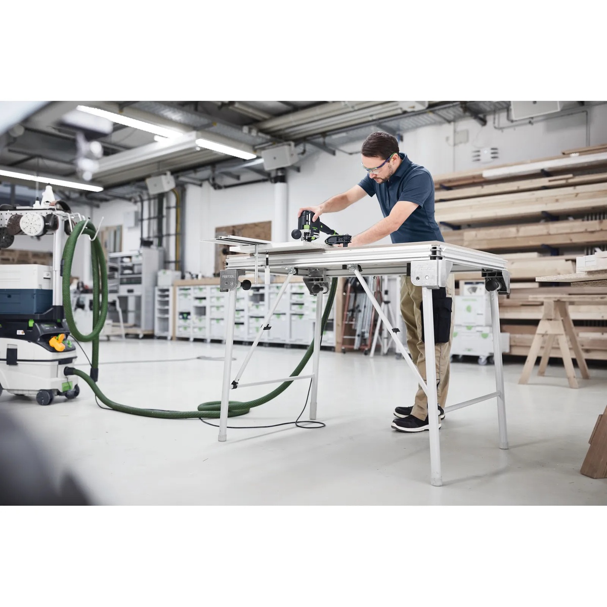 Festool 495502 Cross Members installed on an MFT multifunction table while cutting sheet material in a workshop setting