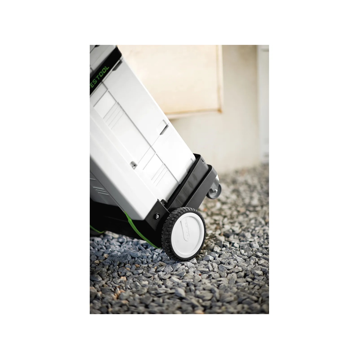 Festool 498660 Sys-Roll Systainer Cart rolling a loaded Systainer stack over gravel outdoors, showing the large rear wheels and stable cart base
