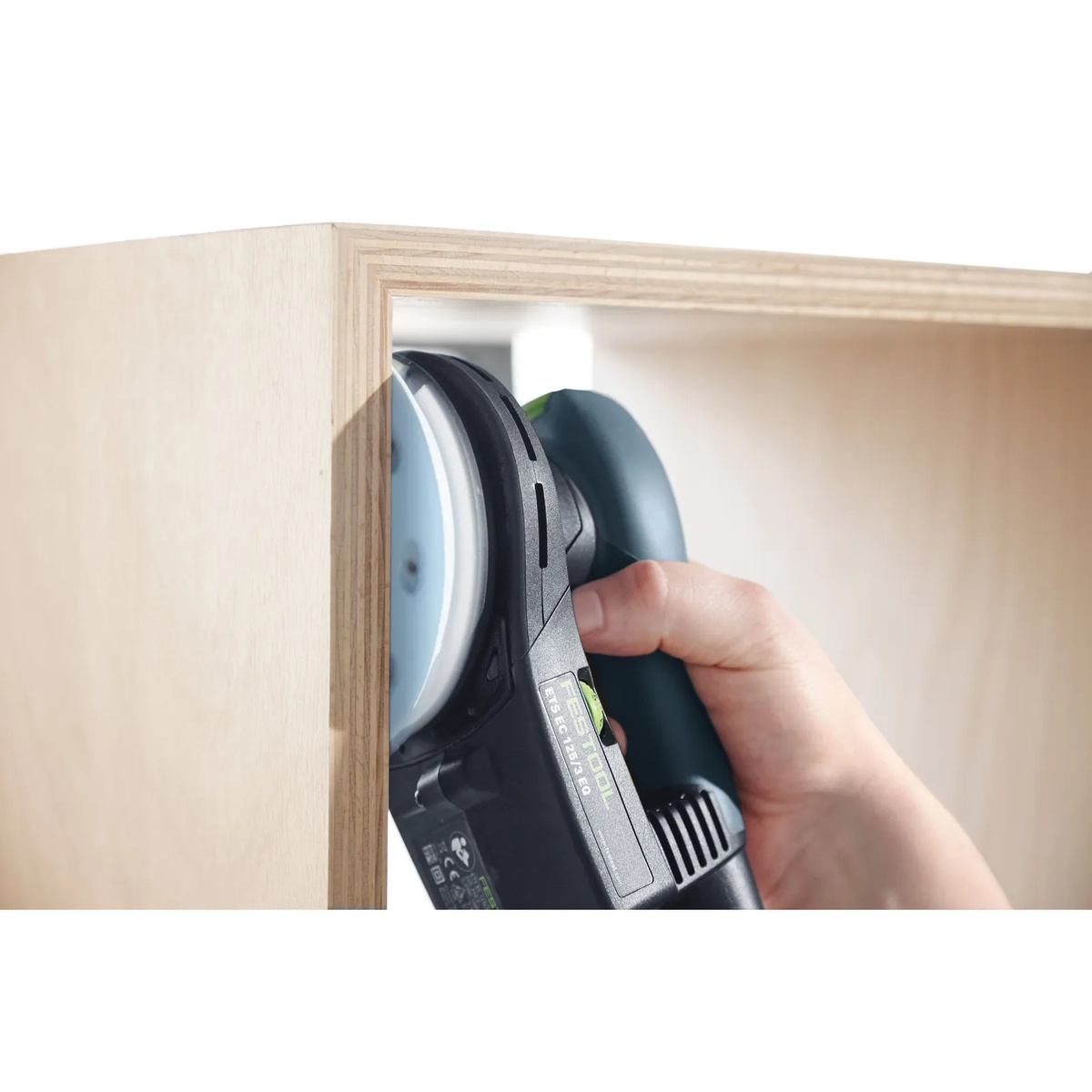 Festool ST D125-M8-H Sanding Pad on a compact Festool sander working inside a plywood cabinet corner for edge and panel sanding