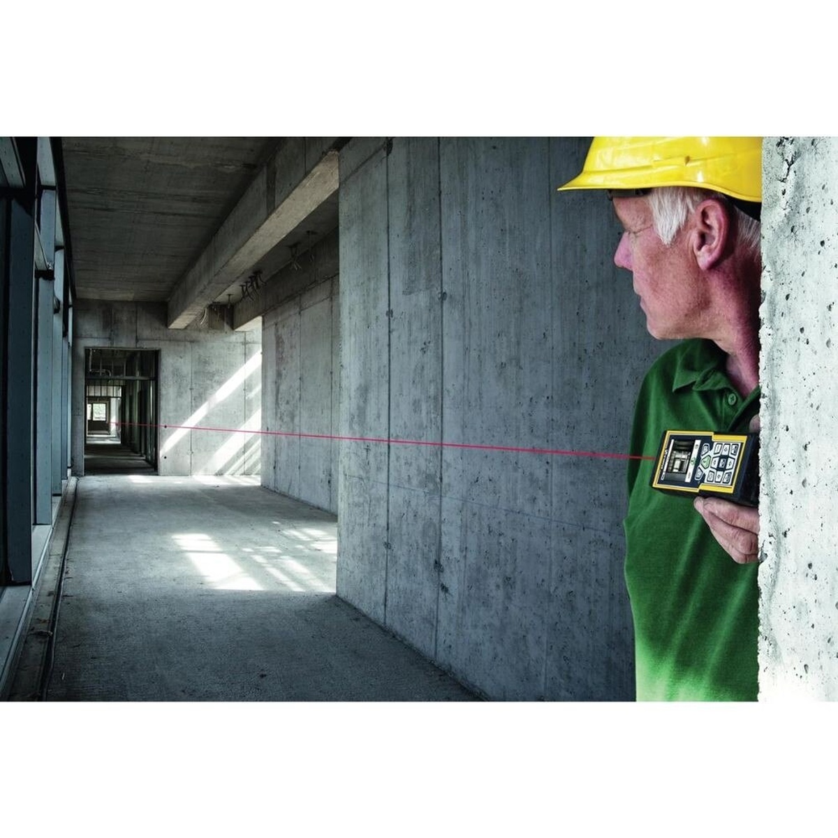 Stabila 06520 laser distance measurer used in a concrete hallway for interior layout and distance measurement